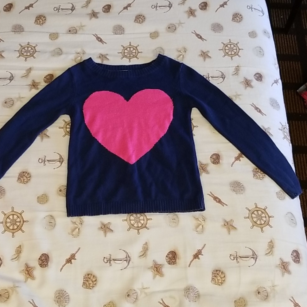 A sweater with a huge pink heart in the middle